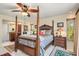 Bedroom with four-poster bed, ceiling fan, tiled floor, bedside table, and window at 24398 Treasure Island Blvd, Punta Gorda, FL 33955