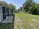 Backyard with green space, shed, and screened porch, offering great potential at 2443 Lake View Blvd, Port Charlotte, FL 33948
