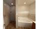 Bathroom with walk-in tiled shower, garden tub and wood vanity with countertop at 2443 Lake View Blvd, Port Charlotte, FL 33948