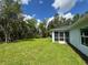 View of the backyard showing green grass and some trees at 2451 Waller Rd, North Port, FL 34288