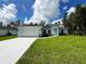 Charming single-story home with lush lawn, showcasing a clean, modern design with a two-car garage and light blue color palette at 2451 Waller Rd, North Port, FL 34288