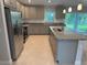 Well-equipped kitchen with stainless steel appliances, granite countertops, a kitchen island, and ample cabinet space at 2451 Waller Rd, North Port, FL 34288