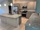 Well-equipped kitchen with stainless steel appliances, granite countertops, a kitchen island, and ample cabinet space at 2451 Waller Rd, North Port, FL 34288