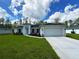 Charming single-story home with a manicured lawn, a two-car garage, and beautiful landscaping at 2461 Waller Rd, North Port, FL 34288