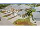 An aerial view of the residential neighborhood showcasing townhouses, attached garages, mature trees, and a nearby pond at 25555 Heritage Lake Blvd # 27, Punta Gorda, FL 33983