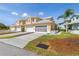 Inviting yellow townhomes featuring attached garages and well-maintained landscaping, offering a comfortable and stylish living environment at 25555 Heritage Lake Blvd # 27, Punta Gorda, FL 33983