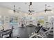 Community gym featuring exercise equipment, ceiling fans, bright lighting, and multiple windows overlooking the grounds at 25555 Heritage Lake Blvd # 27, Punta Gorda, FL 33983