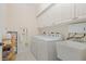 Bright laundry room features a washing machine, dryer, utility sink, overhead cabinets, and storage solutions at 25555 Heritage Lake Blvd # 27, Punta Gorda, FL 33983