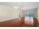 Bright and airy living room featuring hardwood floors, a modern chandelier, and sliding glass doors with water views at 25555 Heritage Lake Blvd # 27, Punta Gorda, FL 33983