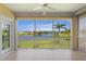 Covered patio features serene water views, tile flooring, a ceiling fan, and screened enclosure for outdoor enjoyment at 25555 Heritage Lake Blvd # 27, Punta Gorda, FL 33983