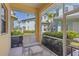 Cozy screened porch with outdoor seating and scenic views of palm trees and neighboring townhomes at 25555 Heritage Lake Blvd # 27, Punta Gorda, FL 33983