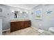 Bathroom with double sinks, granite counters, wood cabinets, and updated fixtures at 26125 Copiapo Cir, Punta Gorda, FL 33983