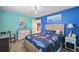 Bedroom with cheerful blue walls, wood floors, and a shark-themed comforter at 26125 Copiapo Cir, Punta Gorda, FL 33983