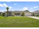 Charming single-story home featuring a well-manicured lawn and tropical landscaping at 26125 Copiapo Cir, Punta Gorda, FL 33983