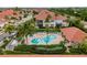 Aerial view of a community featuring a pool, spa, lush landscaping, and residential buildings with tile roofs at 2630 Tarpon Cove Dr # 212, Punta Gorda, FL 33950