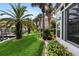 Scenic backyard featuring a well-maintained lawn, mature palm trees, and waterfront views, leading to a private boat dock at 2630 Tarpon Cove Dr # 212, Punta Gorda, FL 33950