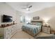 Comfortable bedroom with plantation shutters, dresser with TV, and blue bedding at 2630 Tarpon Cove Dr # 212, Punta Gorda, FL 33950