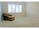 Spacious room featuring neutral carpet, a comfortable chair with ottoman, and plantation shutters for natural light at 2630 Tarpon Cove Dr # 212, Punta Gorda, FL 33950