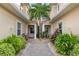 Beautiful front entrance with brick pavers, a central palm tree, and symmetrical landscaping on either side at 2630 Tarpon Cove Dr # 212, Punta Gorda, FL 33950