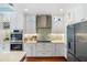 Modern kitchen with stainless steel appliances, mosaic backsplash, and custom white cabinetry at 2630 Tarpon Cove Dr # 212, Punta Gorda, FL 33950