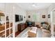 Well-lit home office featuring hardwood floors, a ceiling fan, plantation shutters, and a comfortable seating area at 2630 Tarpon Cove Dr # 212, Punta Gorda, FL 33950