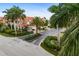 Street view of a residential community with lush landscaping, mature palm trees, and well-maintained homes with tile roofs at 2630 Tarpon Cove Dr # 212, Punta Gorda, FL 33950