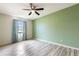 Bright bedroom features durable laminate floors, ceiling fan and light filled window with lovely blue curtains at 3242 Nocturne Rd, Venice, FL 34293