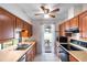 Traditional kitchen features wood cabinets, tile flooring, and stainless steel appliances, offering a cozy cooking space at 3242 Nocturne Rd, Venice, FL 34293