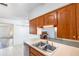 Traditional kitchen features wood cabinets, tile flooring, and dual stainless steel sink at 3242 Nocturne Rd, Venice, FL 34293