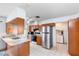 Bright traditional kitchen with wood cabinets, stainless steel appliances, and access to the washroom at 3242 Nocturne Rd, Venice, FL 34293