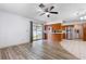 Open-concept living space featuring laminate flooring, access to the kitchen, and sliding doors to the backyard at 3242 Nocturne Rd, Venice, FL 34293