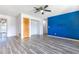 Open-concept living room with updated floors, a modern ceiling fan, and a bold accent wall at 3242 Nocturne Rd, Venice, FL 34293