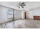 Bright living room with updated floors, a ceiling fan, and natural light from large windows at 3242 Nocturne Rd, Venice, FL 34293