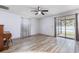 Spacious living room with ceiling fan, laminate flooring, and sliding doors leading to the backyard at 3242 Nocturne Rd, Venice, FL 34293