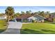 Charming single-story home with mature landscaping, a large front yard, and long driveway at 372 Cory St, Port Charlotte, FL 33953