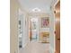 Inviting hallway with tile flooring, artwork, and views into the bathroom and a bedroom at 372 Cory St, Port Charlotte, FL 33953