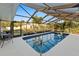 Enclosed swimming pool with blue trim, surrounded by a screened enclosure and greenery at 372 Cory St, Port Charlotte, FL 33953
