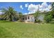 Well-manicured backyard featuring a lush lawn, palm trees, and a charming patio area at 3724 Bordeaux Dr, Punta Gorda, FL 33950