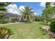 Lush backyard featuring a well-maintained lawn, mature trees, and a screened-in patio area at 3724 Bordeaux Dr, Punta Gorda, FL 33950