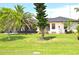 Well-maintained backyard with lush green grass, trees, and an outdoor pool at 3724 Bordeaux Dr, Punta Gorda, FL 33950