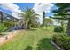 Expansive backyard with lush green lawn, mature palm trees, and screened-in patio for outdoor enjoyment at 3724 Bordeaux Dr, Punta Gorda, FL 33950
