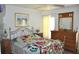 Cozy bedroom with floral bedding, dresser with mirror and beach themed artwork at 3724 Bordeaux Dr, Punta Gorda, FL 33950