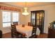 Bright dining room with hardwood floors, chandelier and hutch with glass doors at 3724 Bordeaux Dr, Punta Gorda, FL 33950