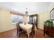 Cozy dining room with hardwood floors, chandelier, and large window with custom shades at 3724 Bordeaux Dr, Punta Gorda, FL 33950
