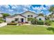 Charming single-story home with a well-manicured lawn, colorful flower beds, and a welcoming blue front door at 3724 Bordeaux Dr, Punta Gorda, FL 33950