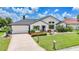 Well-maintained home with a brick driveway, lush lawn, and colorful landscaping at 3724 Bordeaux Dr, Punta Gorda, FL 33950