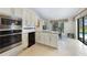 Open kitchen with stainless steel appliances and eat-in dining area overlooking the pool and outdoor living space at 3724 Bordeaux Dr, Punta Gorda, FL 33950