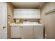 Well-equipped laundry room with white cabinets, sink, washer, and dryer at 3724 Bordeaux Dr, Punta Gorda, FL 33950