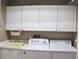 Functional laundry room with white cabinets and stacked washer and dryer at 3724 Bordeaux Dr, Punta Gorda, FL 33950