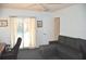 Bright living room featuring a gray sofa, desk, and sliding glass door with floral curtains overlooking the pool at 3724 Bordeaux Dr, Punta Gorda, FL 33950
